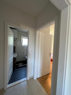 Ein Flur mit einer Tür zu einem Badezimmer und einem Schlafzimmer.