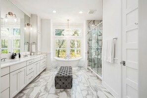 Une salle de bain moderne avec une baignoire sur pieds, une douche à parois de verre et un sol en marbre.
