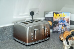 Een keuken met een broodrooster op het aanrecht, een tijdschrift en een zak brood.