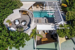 An aerial view of a resort with a swimming pool, sun loungers, and a covered deck area. - New Listing (Grande Saline)