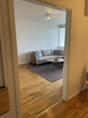 A living room with a sofa, a coffee table, and a rug. - New Listing (Handen)