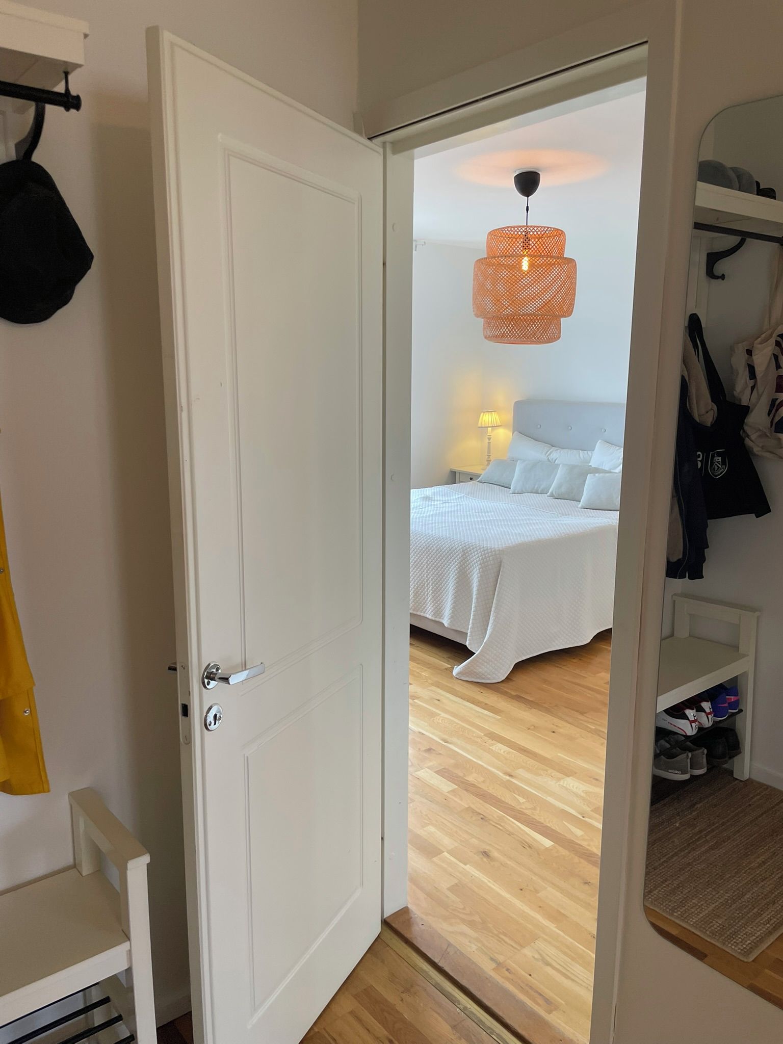 A room with a bed, a hanging light fixture, and a wardrobe.