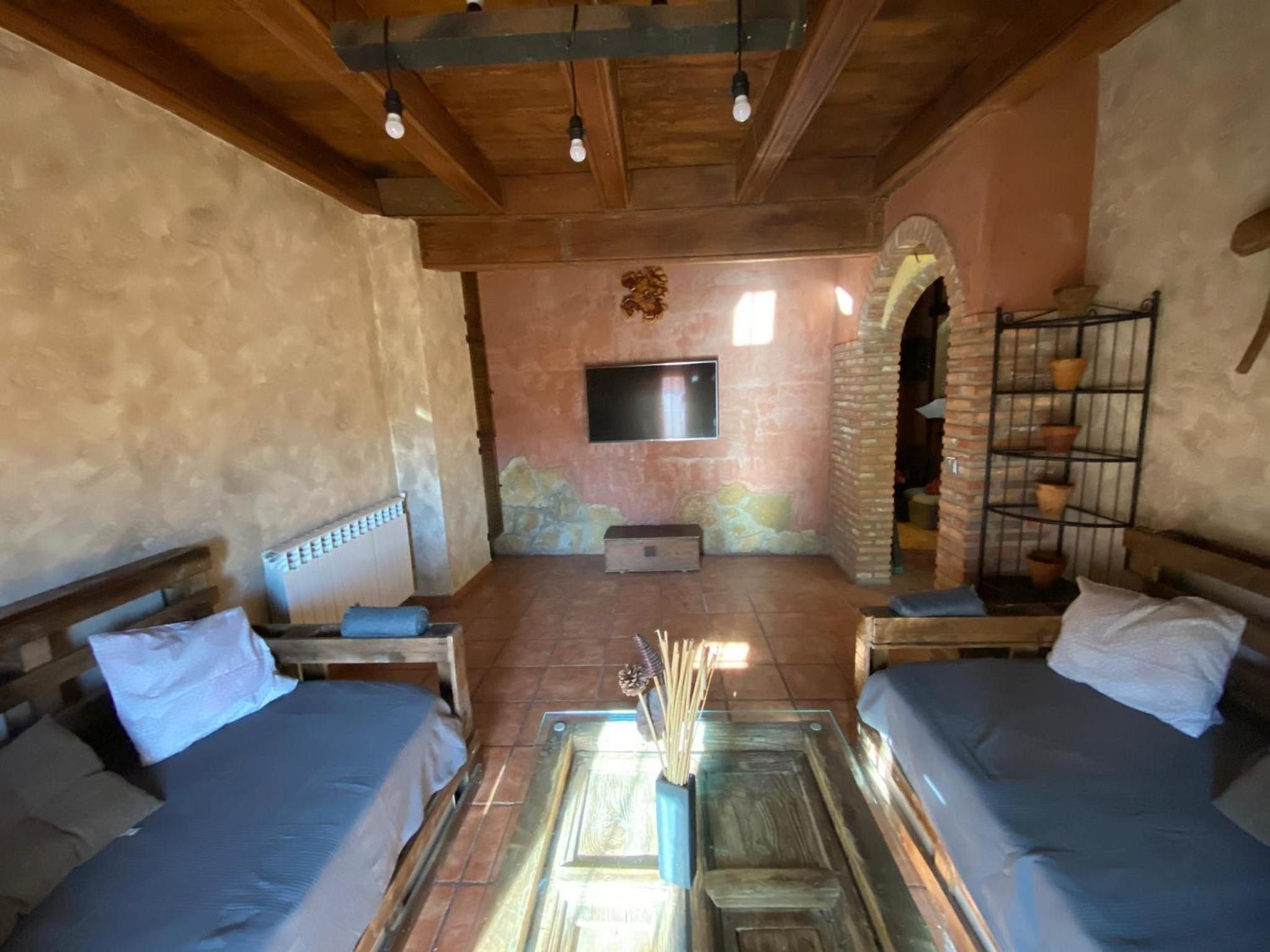 A rustic room with a fireplace, a television, and a brick oven.