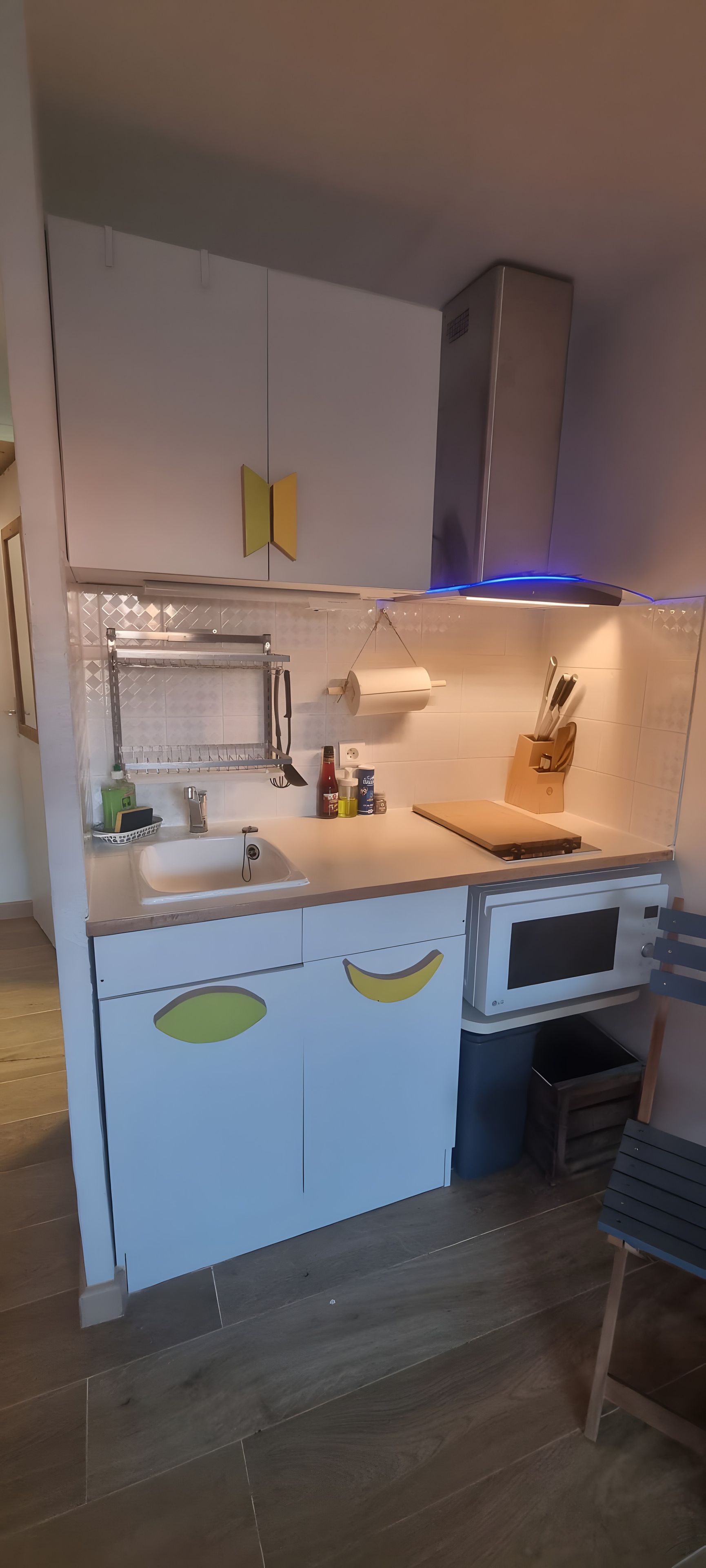 A kitchen with a built-in oven, a sink, and a countertop with various kitchen items.