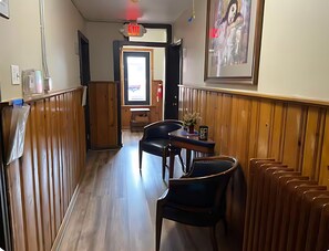Interior de restaurante com painéis de madeira, uma mesa com cadeiras e sinal de saída.