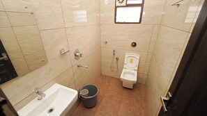 Un baño pequeño con lavamanos, inodoro y ducha.