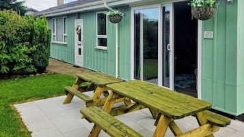 A building with a green exterior, a number '20' sign, and a picnic table outside.