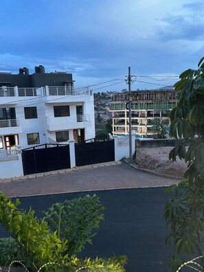 A residential area with modern buildings, a gated entrance, and a clear sky. - CosyNook apartments (Kigali)