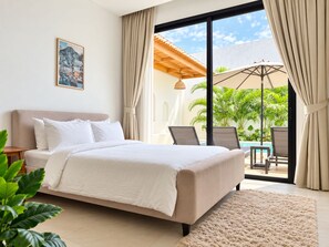 Une chambre avec un lit, donnant sur une piscine extérieure, et ornée d’un tableau au mur.