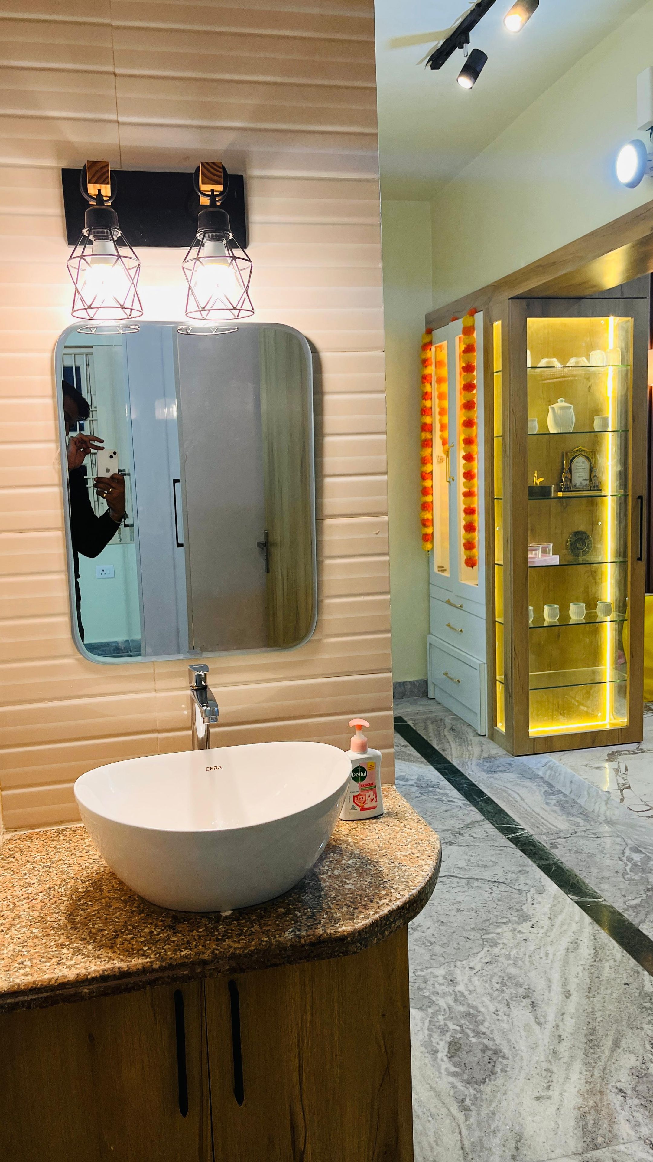 Un baño con un espejo grande, un lavabo redondo y un mueble de tocador con un gabinete de madera.