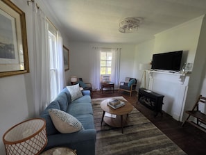 Un salon avec un canapé, une table basse, un téléviseur et une cheminée.