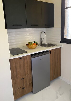 Eine moderne Küche mit Geschirrspüler, Spüle und Obstschale auf der Arbeitsplatte.