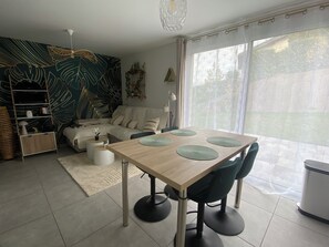 Ett modernt vardagsrum med ett matbord, stolar, en soffa och en dekorativ vägg.