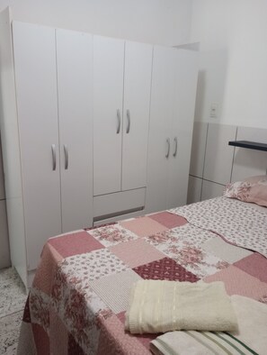 Ein Schlafzimmer mit einem Bett, einem Kleiderschrank und einem Nachttisch.