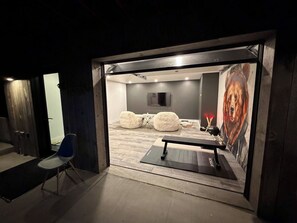 Een kamer met een bed, een bankje en een ruimte voor fitness met een mat.