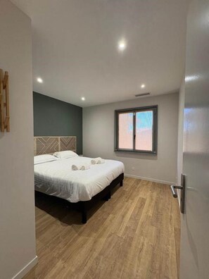 Ein Schlafzimmer mit Bett, Fenster und Tür.