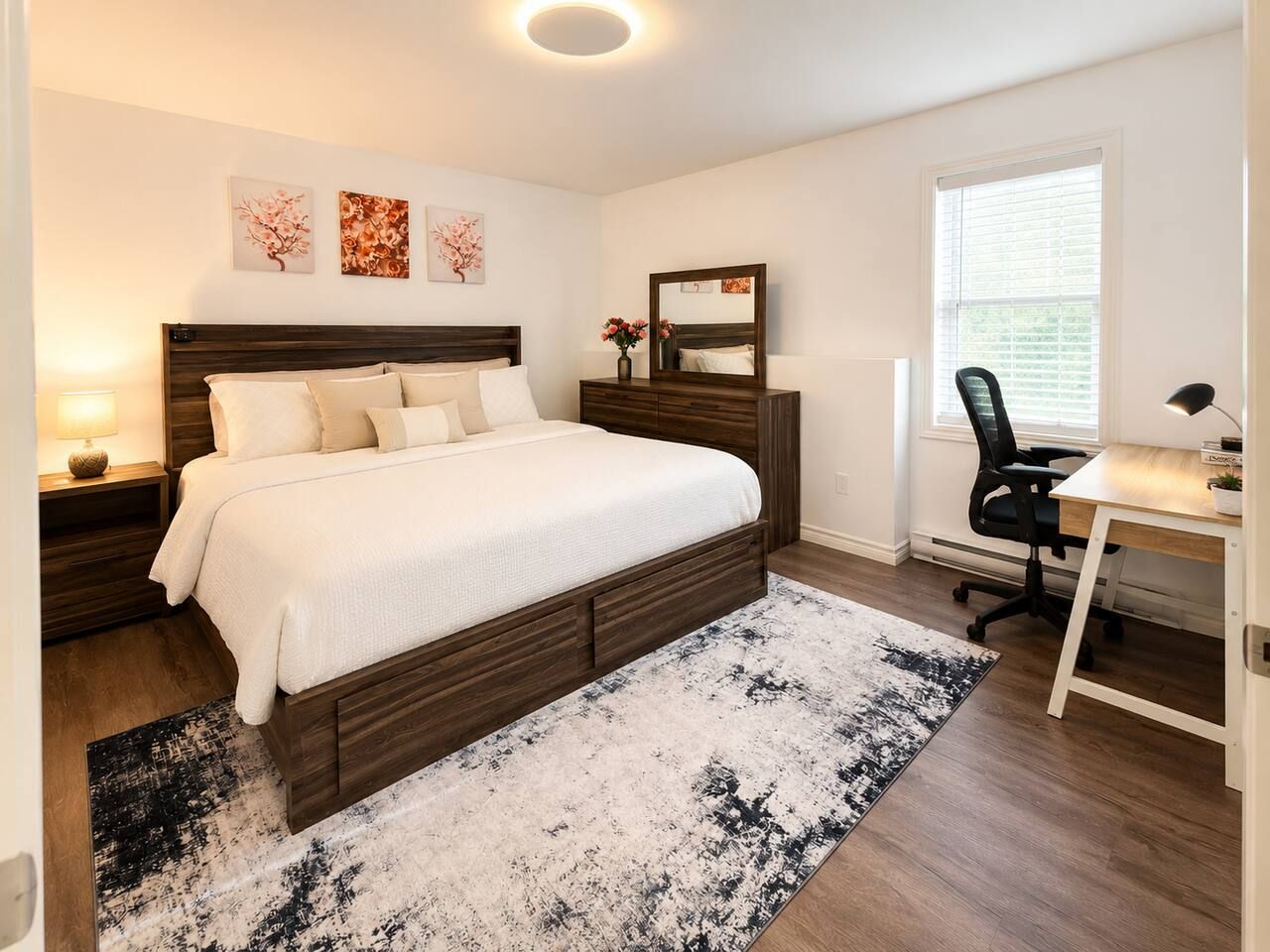 Une chambre à coucher avec un lit, des tables de chevet, un bureau et une chaise.