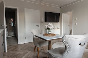 Un espace repas moderne avec une table, des chaises et un vase de fleurs.