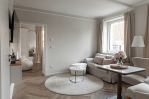 Un salon moderne avec un canapé, une table basse et un téléviseur fixé au mur.