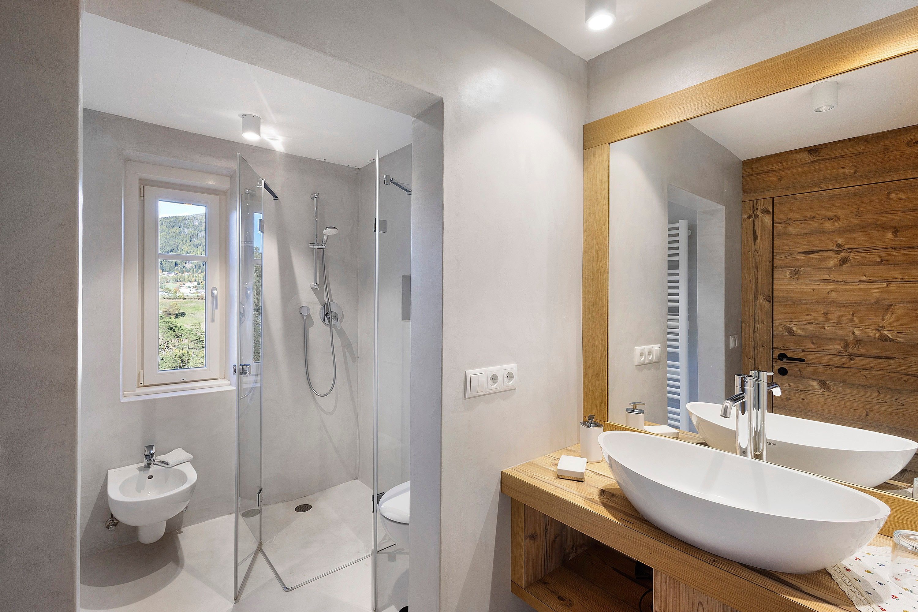 Une salle de bain moderne avec une douche à parois de verre, un meuble-lavabo à deux vasques et un grand miroir.
