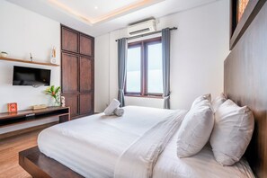 Ett modernt hotellrum med en stor säng, en platt-TV som är monterad på väggen och ett fönster med gardiner.