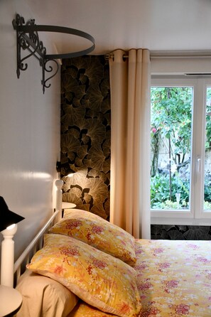 A bedroom with a bed, a stone wall, a window with curtains, and a view of greenery outside. - Bed and Breakfast 'La Chambre' with Shared Terrace, Shared Garden and Wi-Fi (La Rivière-Saint-Sauveur)