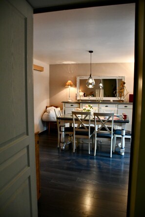 A dining area with a table and chairs, a lamp, and a mirror above the table. - Bed and Breakfast 'La Chambre' with Shared Terrace, Shared Garden and Wi-Fi (La Rivière-Saint-Sauveur)