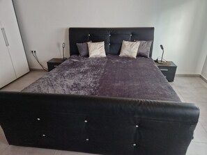 A bedroom with a large bed, two bedside tables, and a wardrobe. - Holiday Apartment 'Lucy' with Shared Terrace, Shared Garden and Wi-Fi (Nattenheim)
