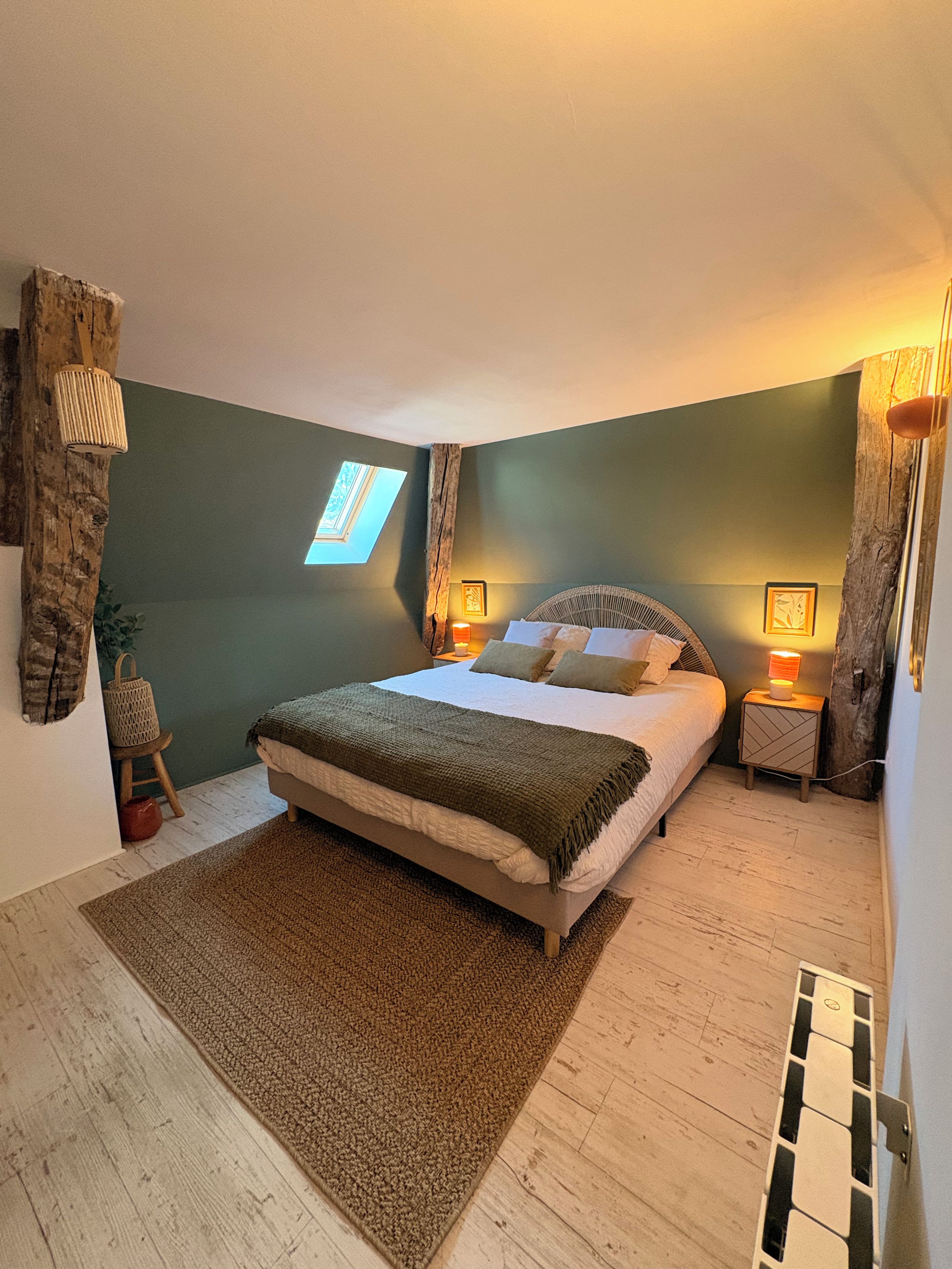 Un dormitorio con cama, lámparas de noche, una ventana y suelo de madera.
