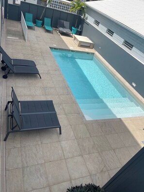 Una piscina amb gandules i una petita zona de seients.