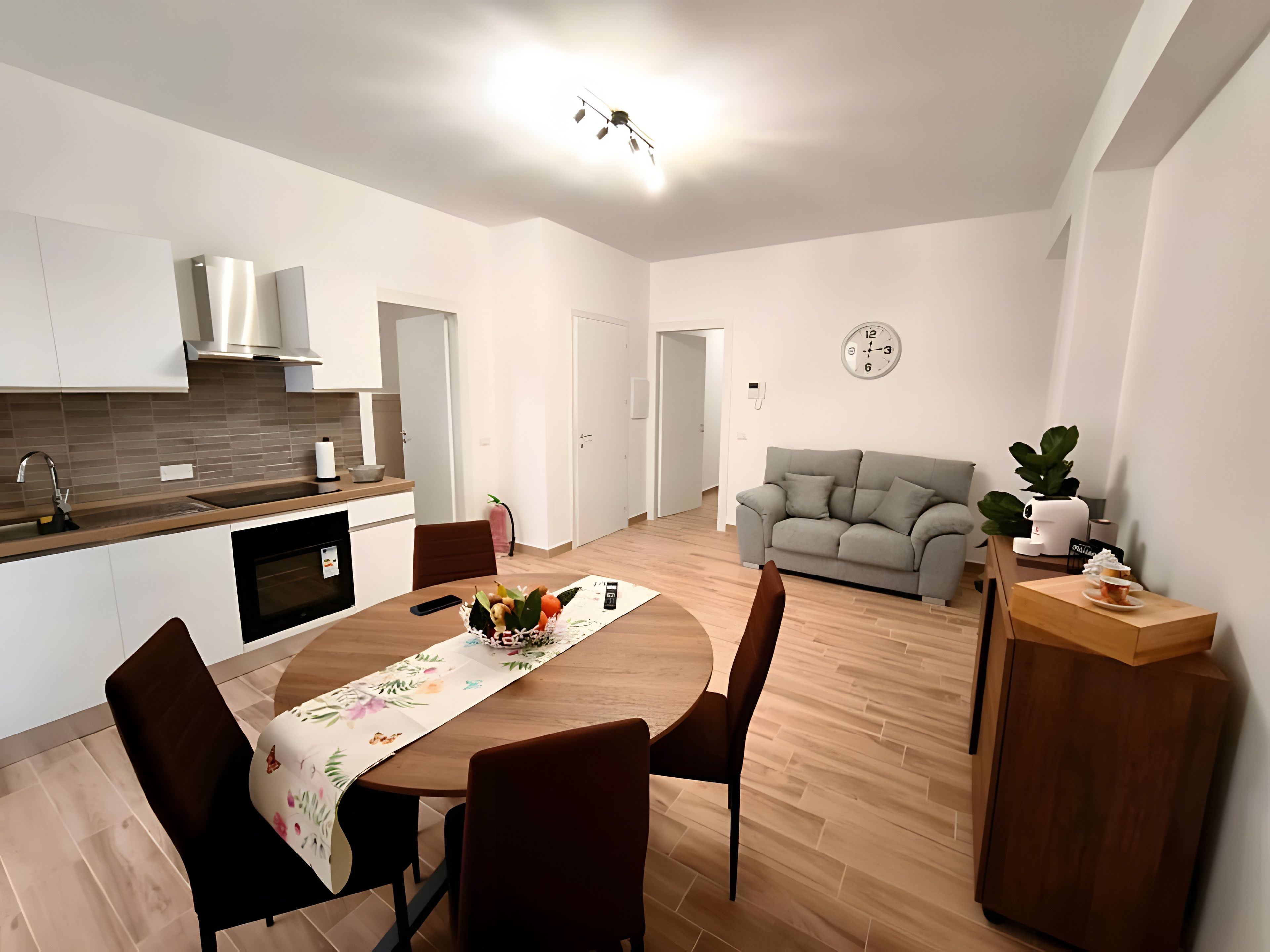 A modern living space with a kitchen, dining area, and seating area.