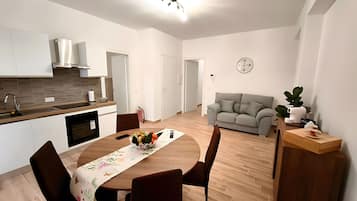 A modern living space with a kitchen, dining area, and seating area.
