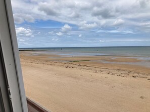 En strand med klar himmel og roligt hav.
