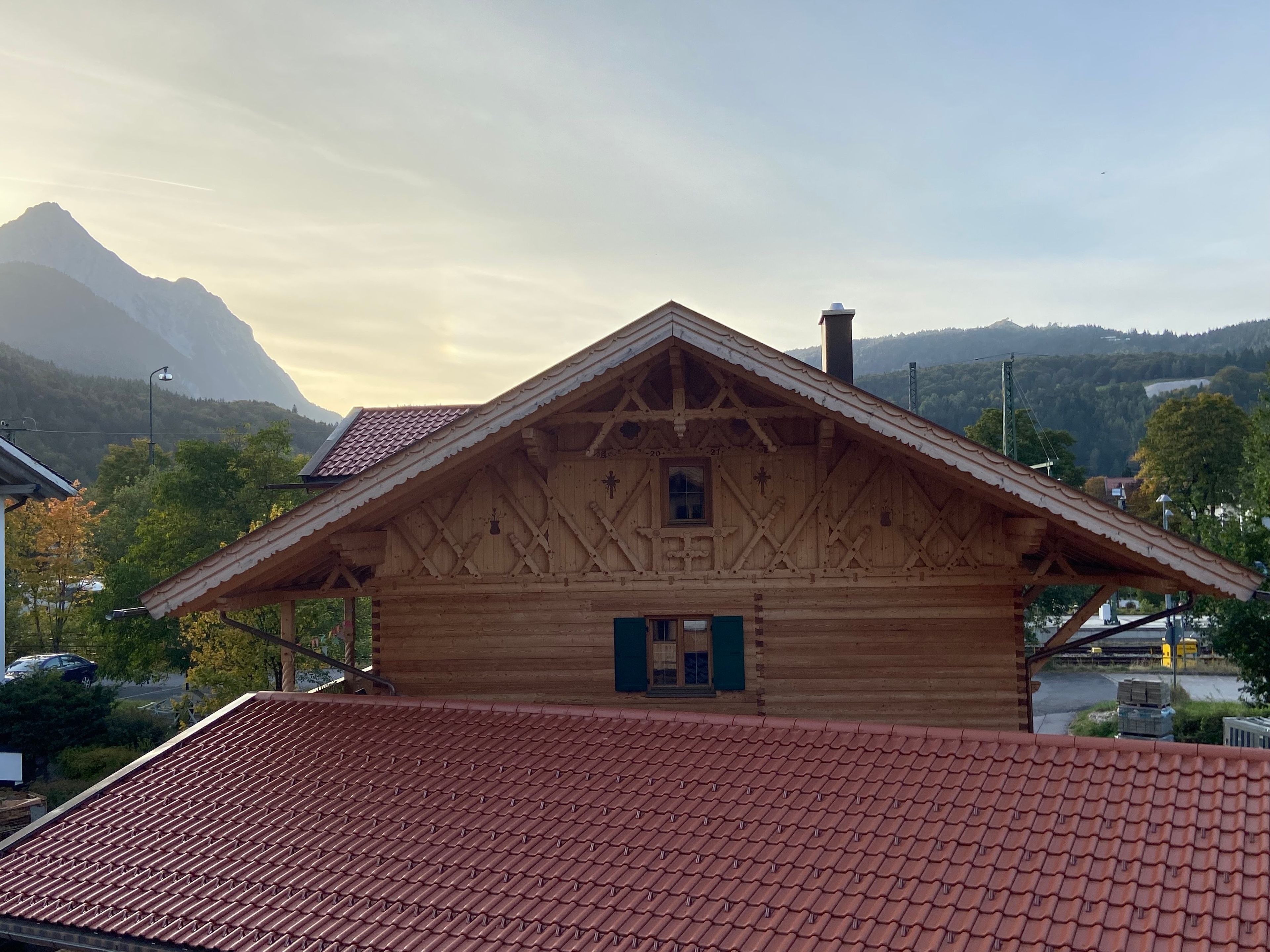 Eine Holzhütte mit steilem Dach, einem kleinen Fenster und einem Schornstein.
