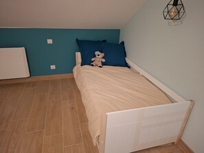 A bedroom with a bed, a blue wall, and a wooden floor. - Room 'Chambre Bleue' with Shared Terrace, Shared Garden and Wi-Fi (Champsevraine)