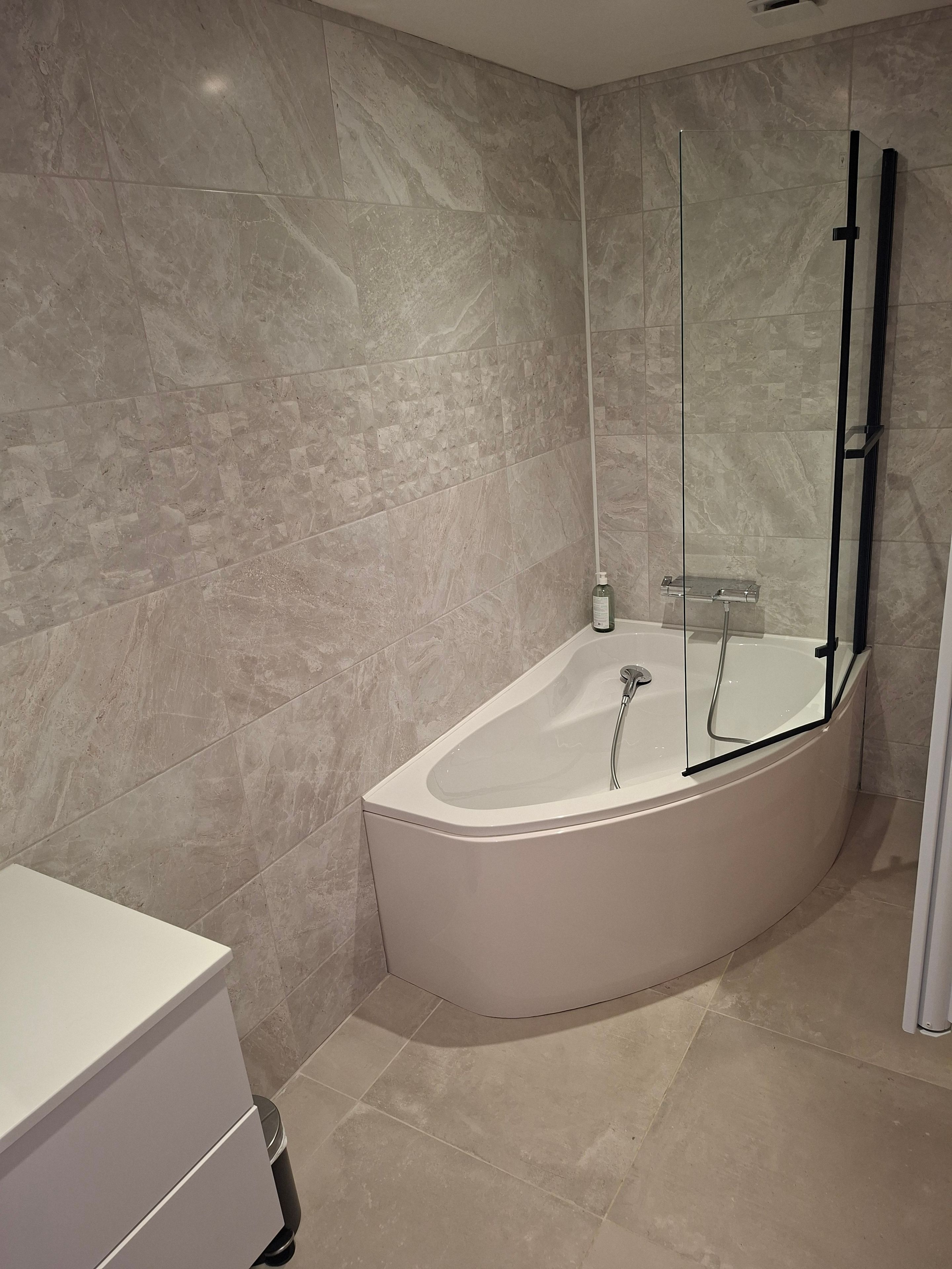 Une salle de bain moderne avec une baignoire sur pieds, une douche à parois de verre et un meuble-lavabo blanc.