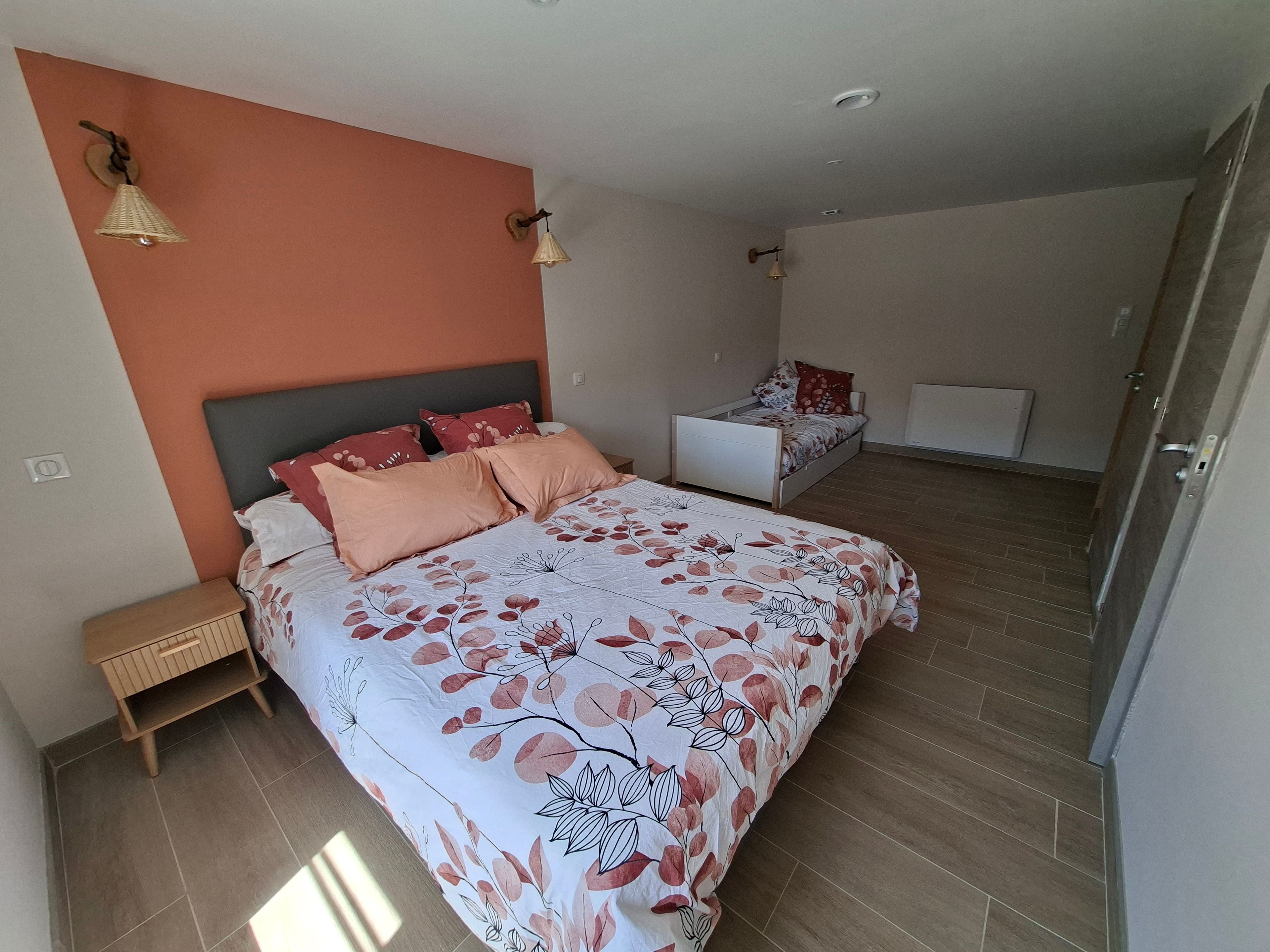 Une chambre à coucher avec un lit, des tables de chevet et une commode.