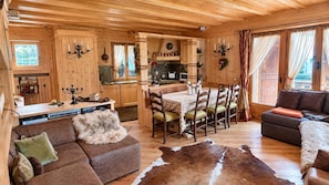 A cozy cabin interior with a dining area, a sofa, and a large fur rug. - Casa Letizia by Ca-sa Check (San Vito di Cadore)