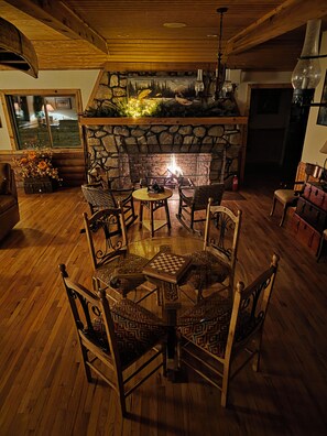 A cozy room with a fireplace, wooden furniture, and a chess table.