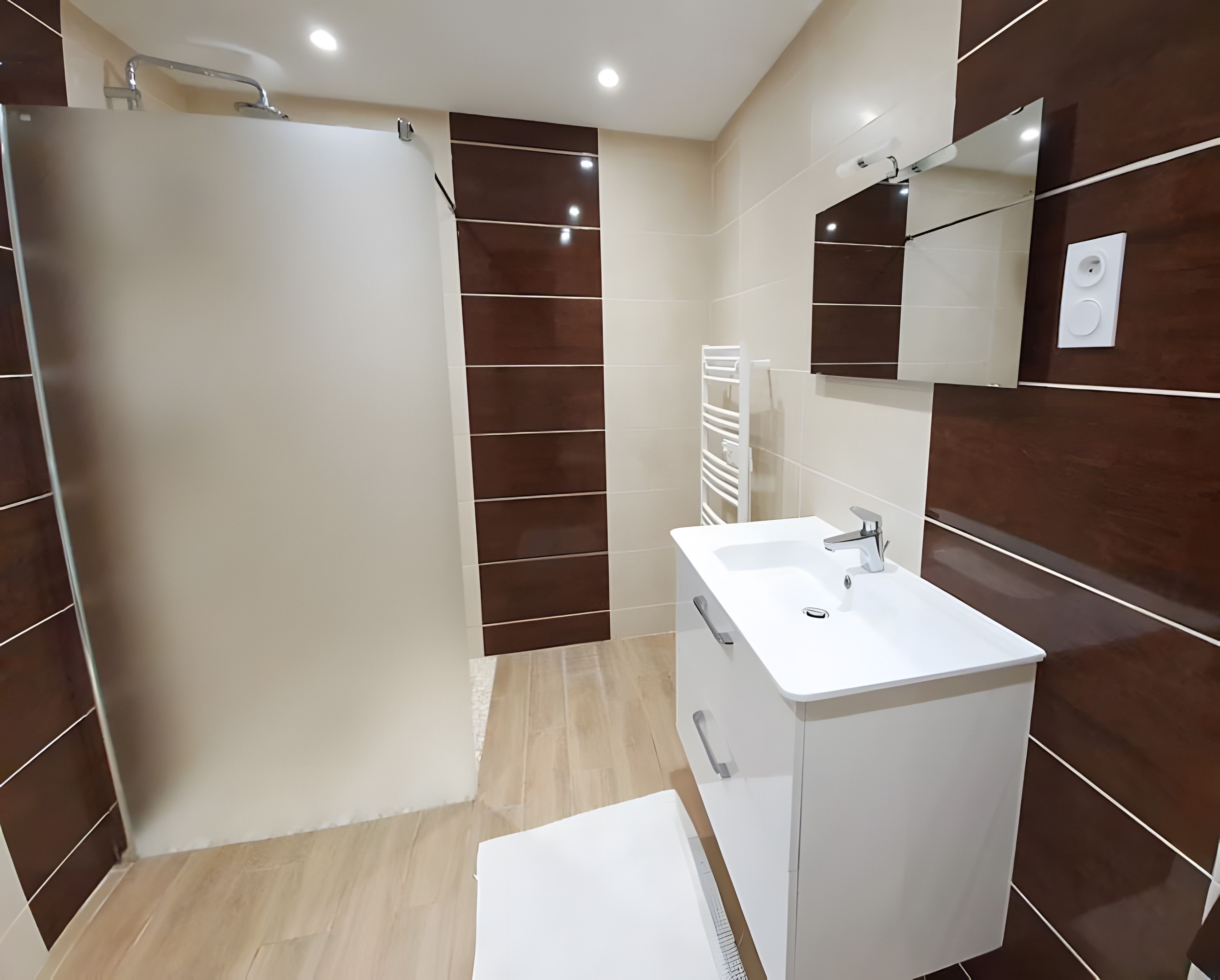 A modern bathroom with a shower, a sink, and a mirror.