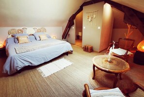 A cozy bedroom with a bed, a chair, a table, and a hanging light fixture. - Bed and Breakfast 'Ma Boheme' with Shared Pool, Shared Terrace and Wi-Fi (Tournes)