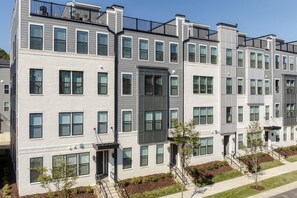 A multi-story residential building with a modern architectural design, featuring balconies and a uniform facade. - Spacious Raleigh Retreat with King Suite, Workspace & Sleeps 6 (Raleigh)