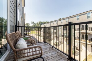 A balcony with wicker furniture and a view of a residential area. - Spacious Raleigh Retreat with King Suite, Workspace & Sleeps 6 (Raleigh)