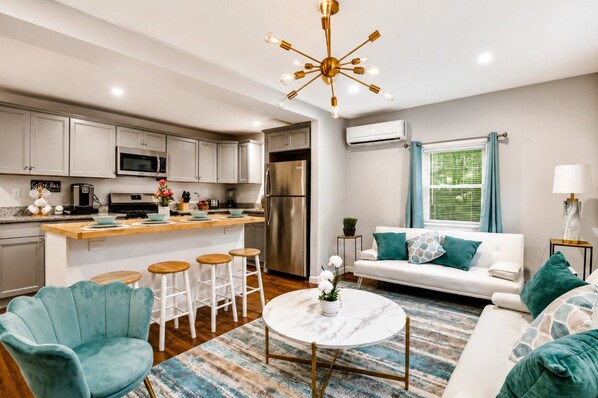 Open-Concept Living & Kitchen — Modern living space flowing into the fully equipped kitchen and breakfast bar.