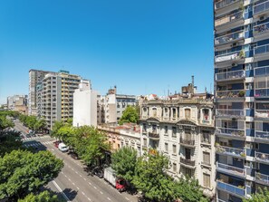 A cityscape with multi-story buildings, a clear sky, and a road with vehicles. - Bright and comfortable apartment in Congreso (Buenos Aires)