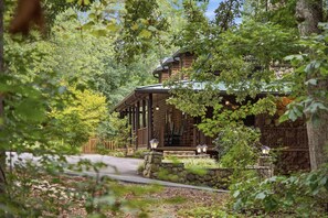 Eine Blockhütte mit Veranda, Steinstufen und einem Weg zum Eingang.