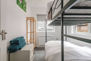 A bunk bed room with a radiator, a drying rack, and a window with a view. - Apartment Sleeps 11 With Paid Parking (Brighton)
