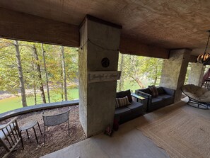 A covered outdoor seating area with a view of trees and a body of water. - Lakefront with dock, kayaks and fire pit on Watauga Lake (Butler)