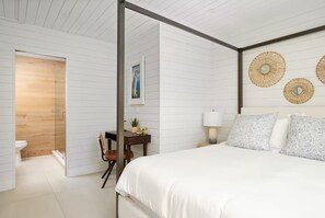 Een slaapkamer met een bed, nachtkastje, lamp en decoratieve wanddecoratie.