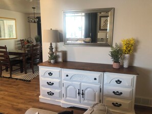 Une commode blanche avec de nombreux tiroirs et un miroir au-dessus.